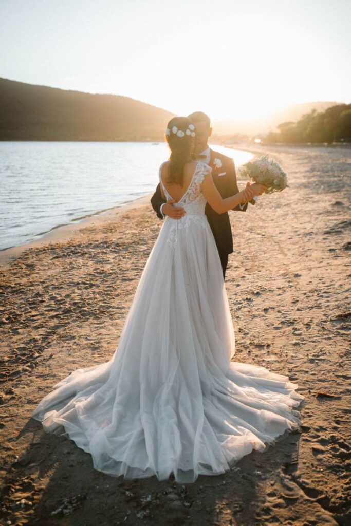 Coppia di sposi su una spiaggia ad Alghero al tramonto