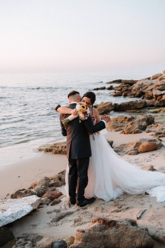 Sposi su una spiaggia con rocce in Sardegna