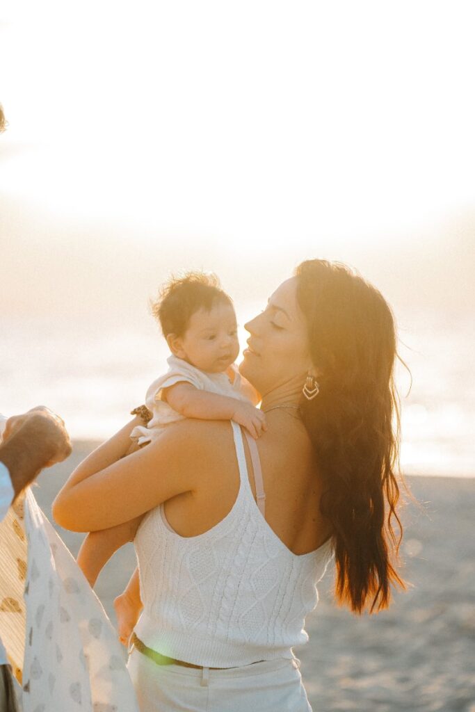 Mamma e figlio in spiaggia al tramonto