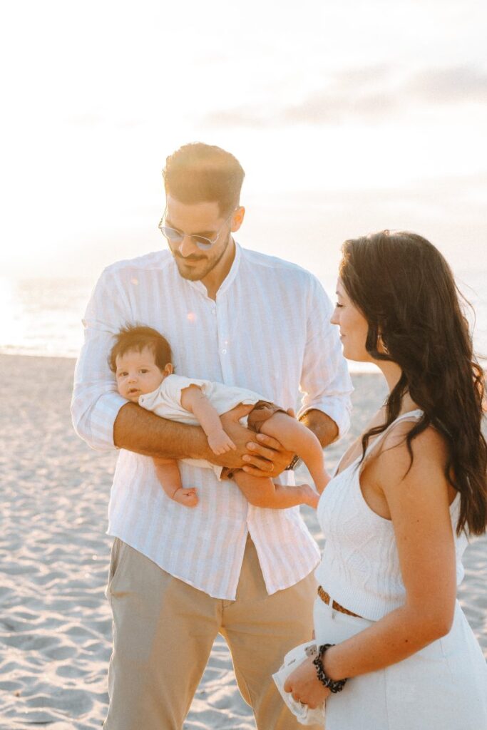 Famiglia con neonato in spiaggia in Sardegna al tramonto