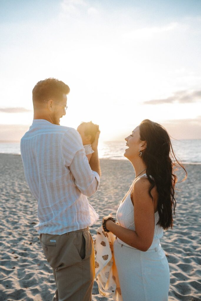Famiglia felice in spiaggia in Sardegna al tramonto
