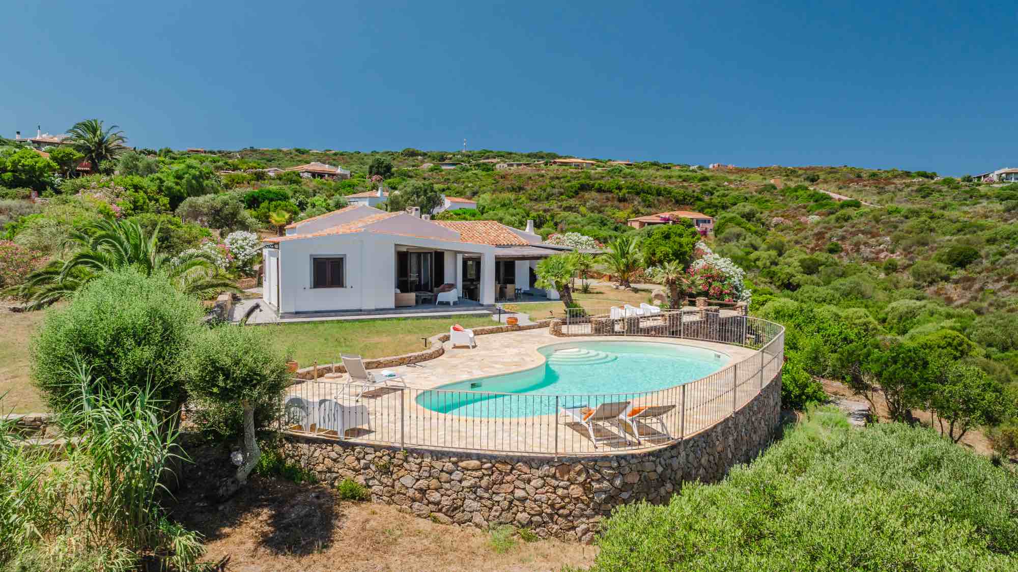 Esterno di una villa in Sardegna con piscina e veranda attrezzata per l'accoglienza degli ospiti